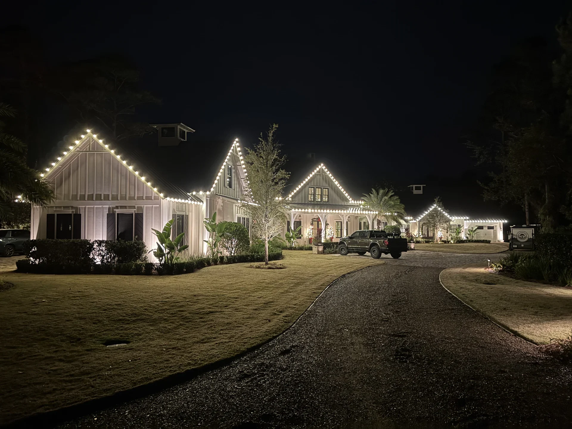 An island home outlined in warm white Christmas lights