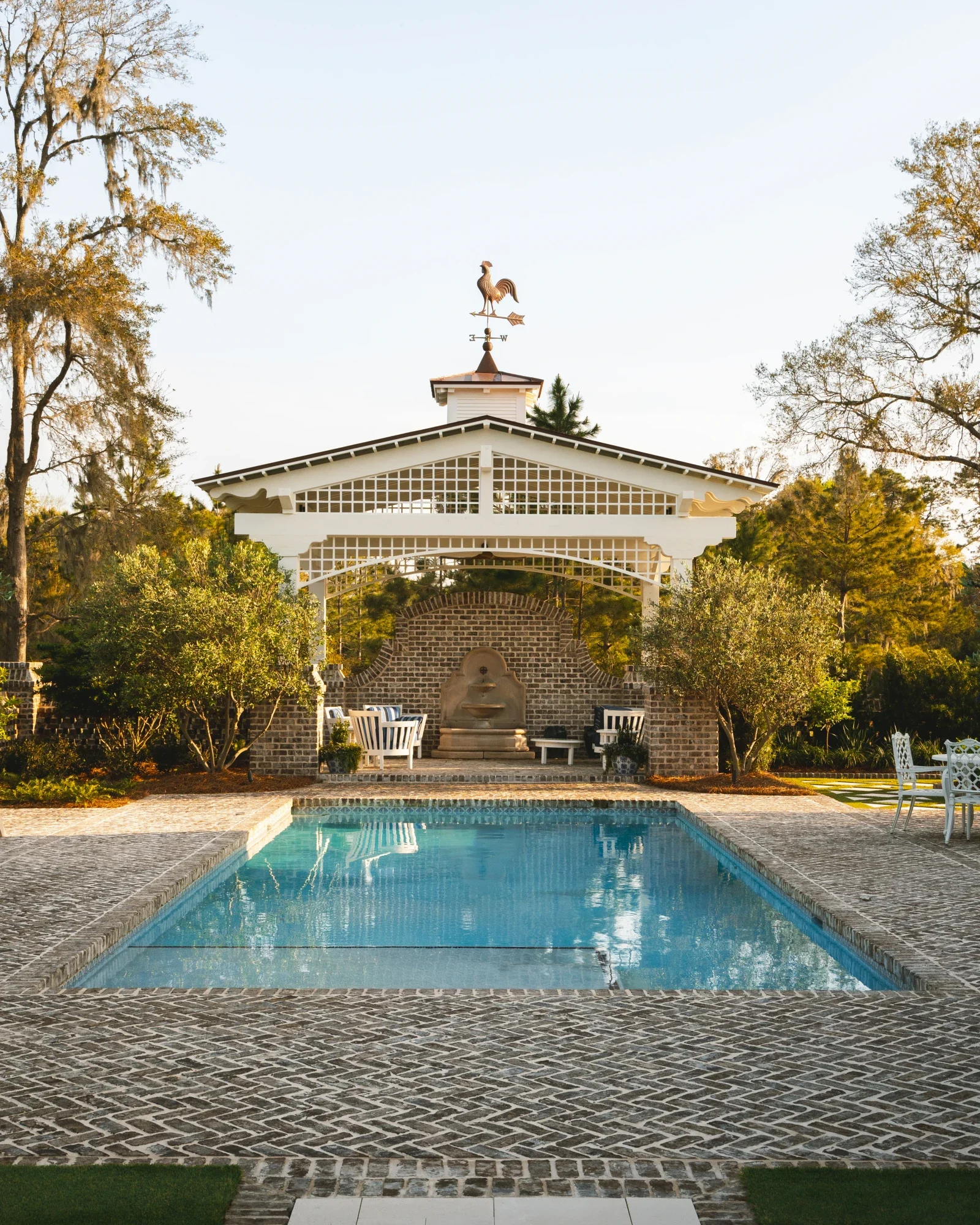 Garden poolhouse and pavilion overlooking a rectangular swimming pool